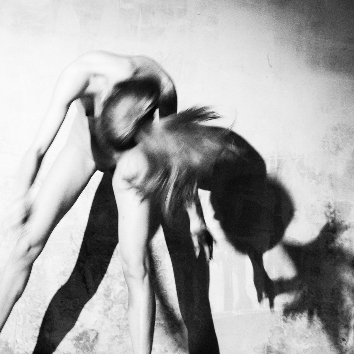 Motion-blurred figure leaning forward beside a doubled shadow.